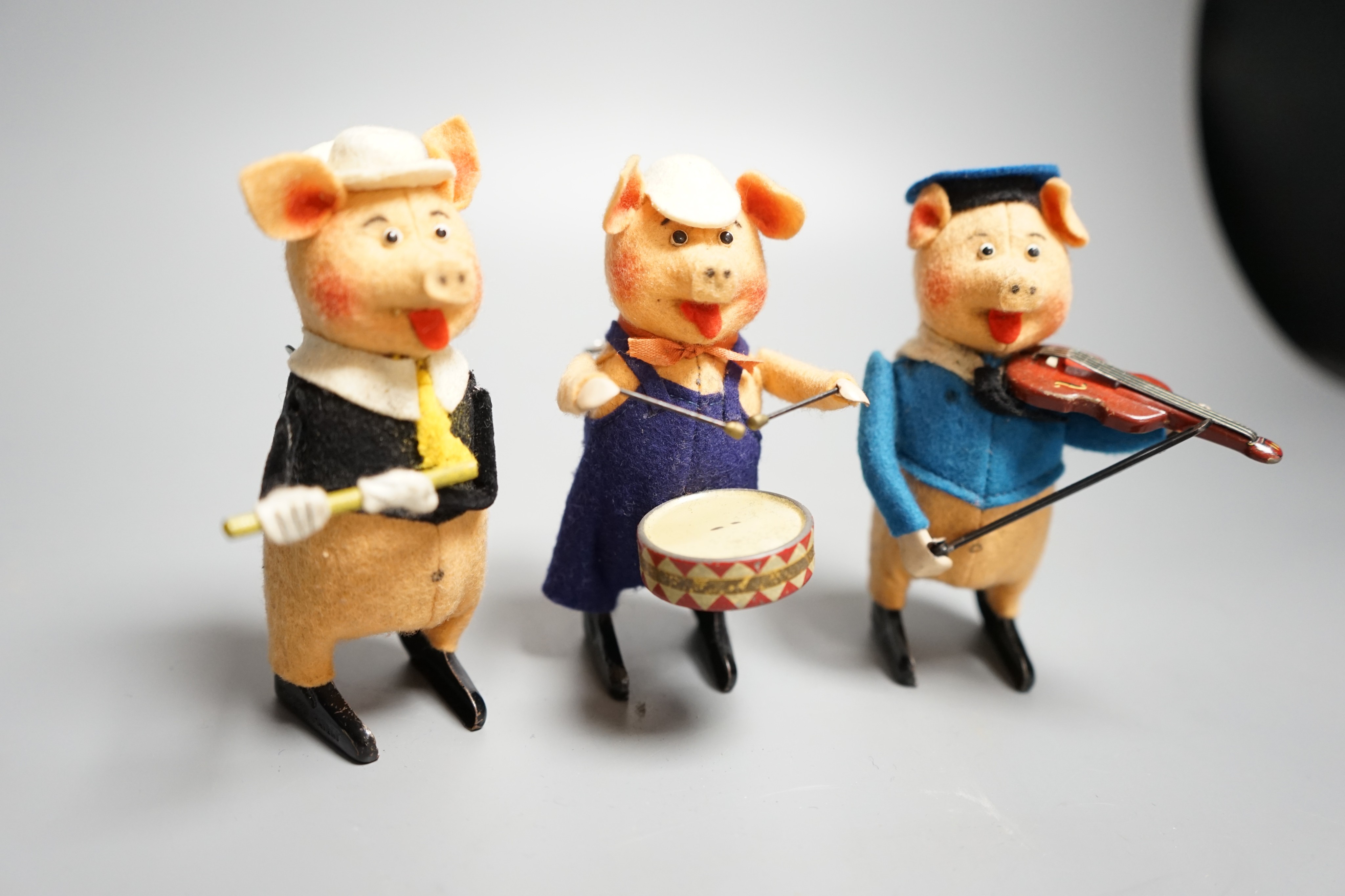 A set of three Schuco tinplate and felt clockwork pig musicians, pre war, tallest 11.5cm